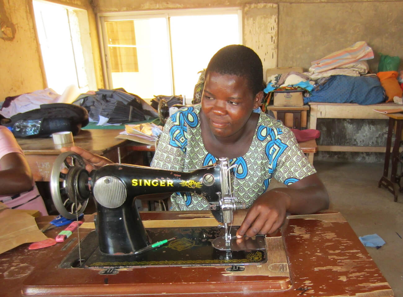 Dama Kahindi on a sewing machine